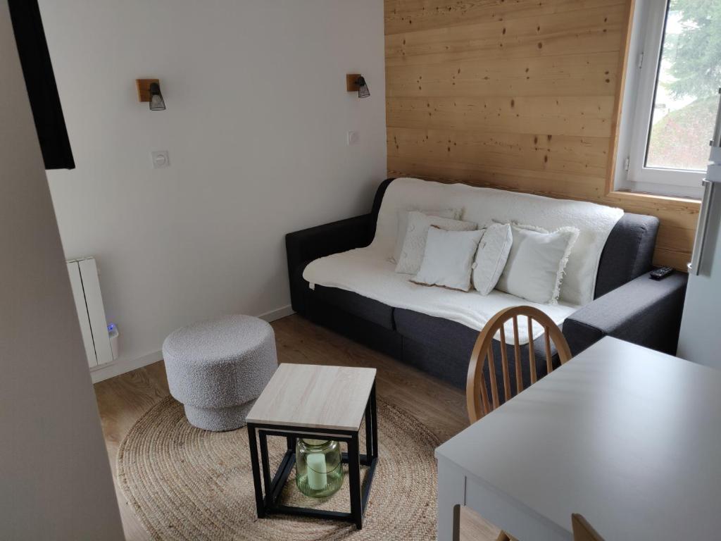 un piccolo soggiorno con divano e tavolo di Appartement neuf 4-6 pers. aux pieds des pistes a Génos