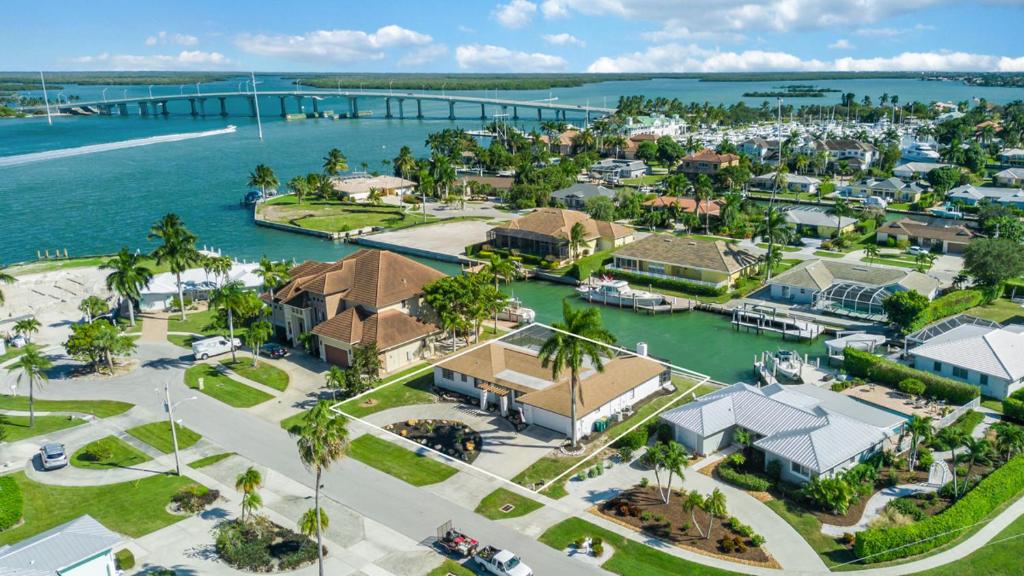 an aerial view of a resort with a marina at ELEVATED - IRIS BY THE BRIDGE - Riverfront in Marco Island