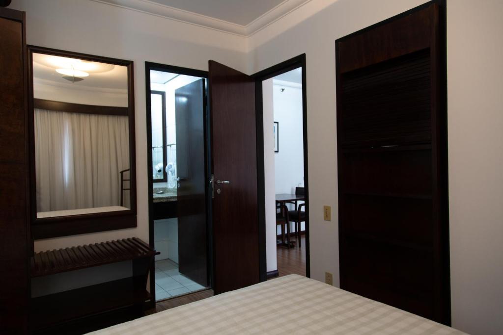 a bedroom with a bed and a mirror at The Palace Flat Moema particular in São Paulo