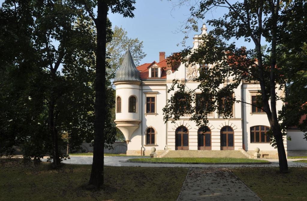 a large white house with a tower on top of it at Pałac Polanka in Krosno