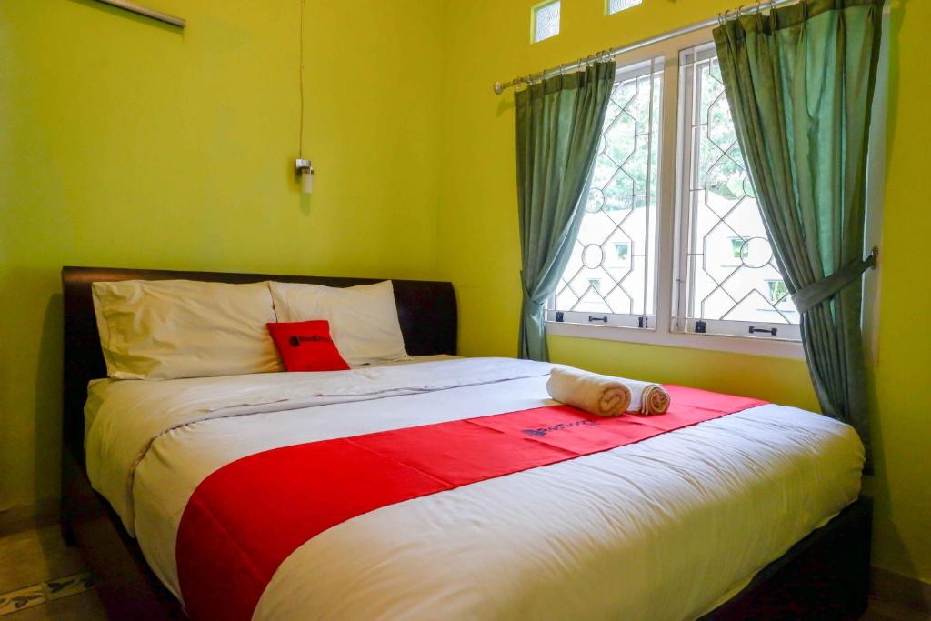 a bedroom with a large bed with a window at RedDoorz near Institut Pertanian Yogyakarta in Yogyakarta