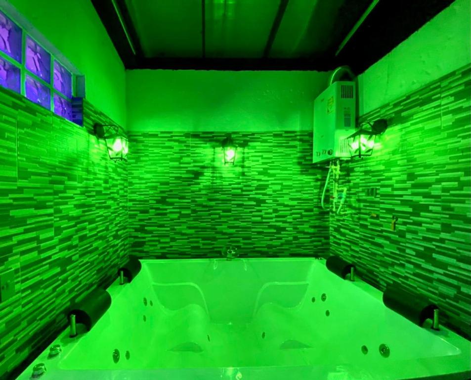 Cette chambre verte comprend une salle de bains pourvue d'une baignoire. dans l'établissement Apartamento turístico jardín Antioquia, à Jardín