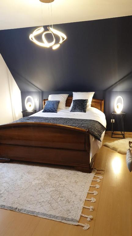 a bedroom with a large bed with a black wall at Chambre d'hôtes Le Lavandin in Kleingoeft