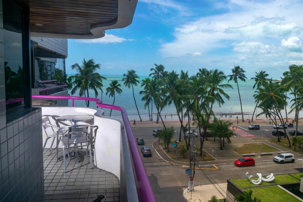 einen Balkon mit Blick auf den Strand und die Palmen in der Unterkunft Vista pro mar in Maceió