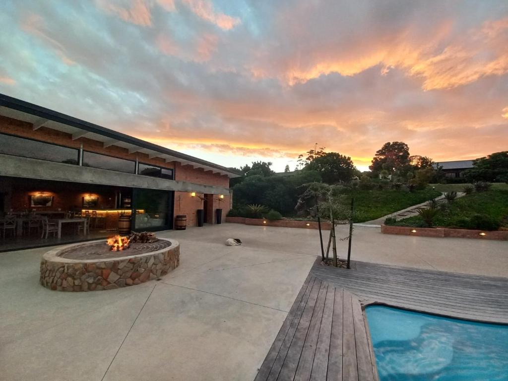 an outdoor patio with a fire pit and a building at Fijnbosch Game Lodge Jeffreys Bay in Jeffreys Bay