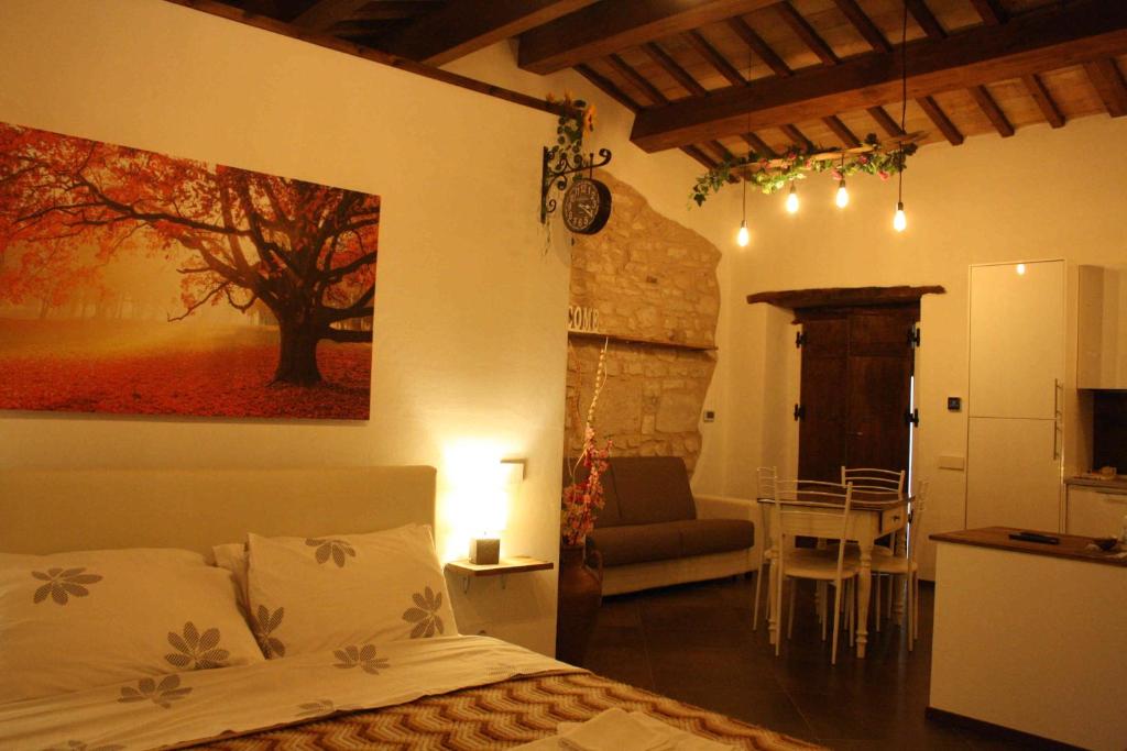 Cet appartement comprend une chambre avec un lit, une cuisine et une table. dans l'établissement L'ALPACA DELLA ROSSA - AGRITURISMO, à Genga