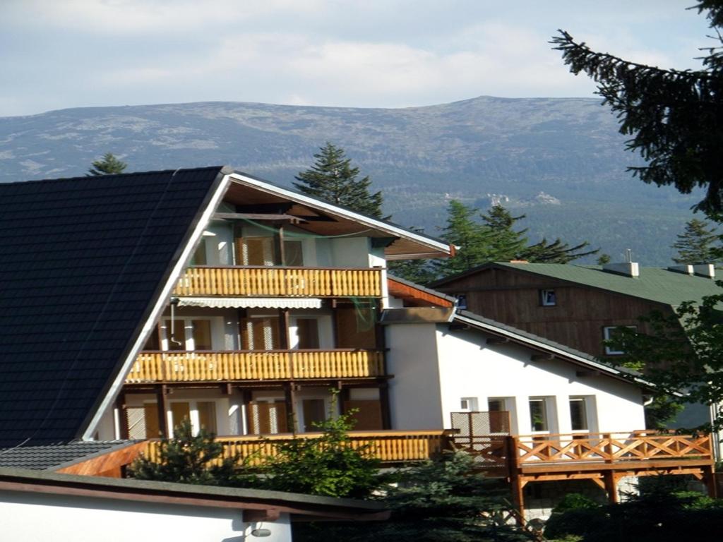 a house with a balcony and mountains in the background at Sylwia in Szklarska Poręba