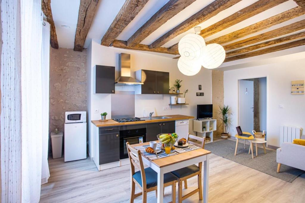 cocina y sala de estar con mesa y sillas en LE VINCI Échappée Amboisienne avec sauna partagé, en Amboise