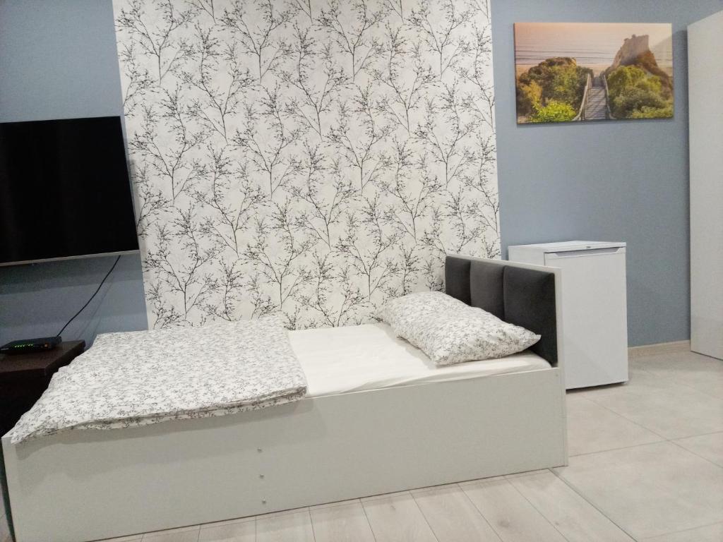 łóżko w pokoju ze ścianą w obiekcie Róża- Lotnisko we Wrocławiu
