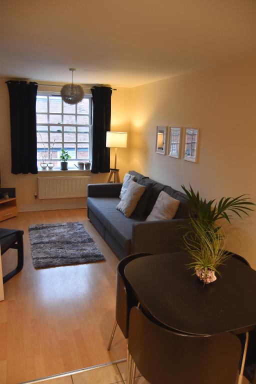a living room with a couch and a table at Scandinavian City Centre Apartment in Worcester