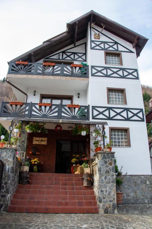 a white building with a staircase in front of it at Casa Albert Sinaia in Sinaia