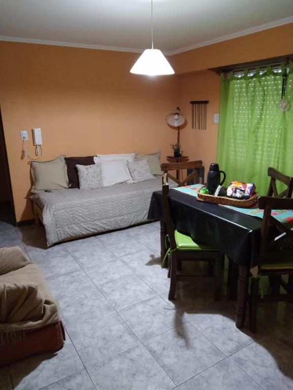 Sala de estar con cama y mesa en Depto Av Pringles en Olavarría