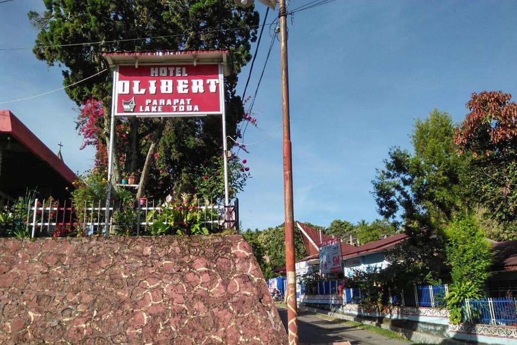 a sign for a restaurant on the side of a street at Hotel Olibert Parapat Ajibata Mitra RedDoorz in Parapat