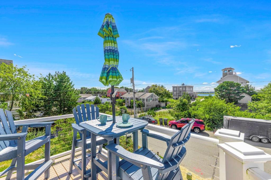 a patio with two chairs and a table with an umbrella at Plovers Nest in Newburyport