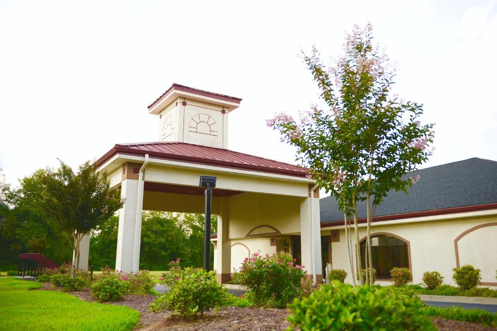 a building with a clock tower on top of it at Red Roof Inn & Suites Commerce - Athens in Commerce