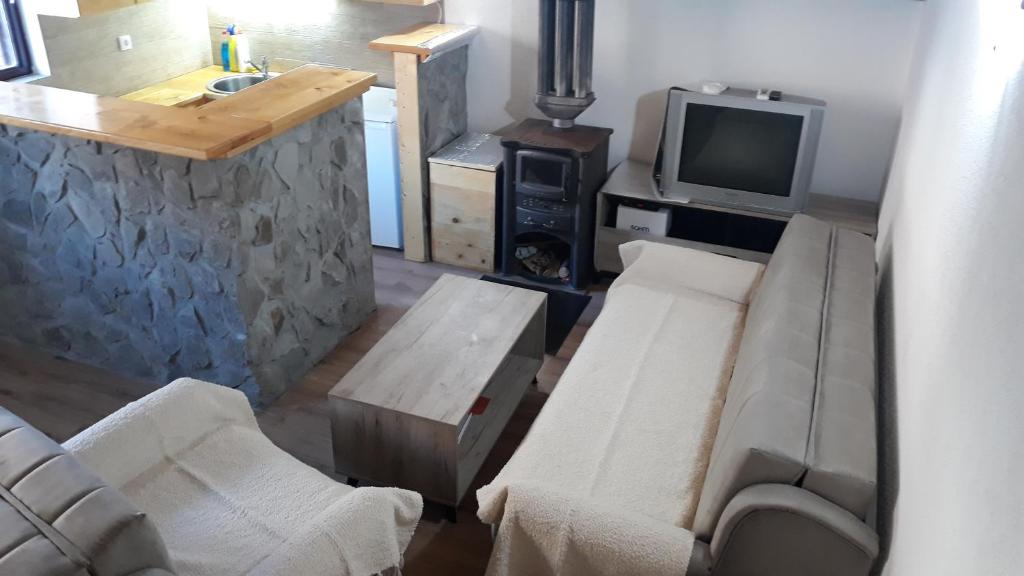 a living room with a couch and a tv at Katun Mokra in Podgorica