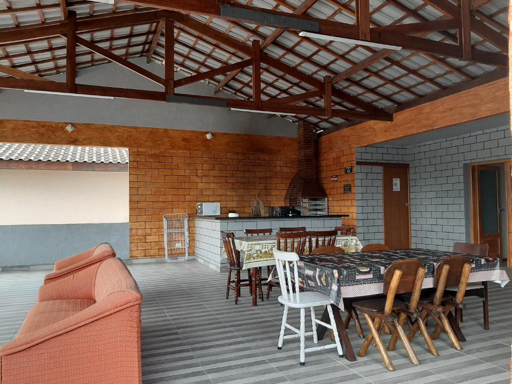 um pátio com uma mesa e cadeiras e uma cozinha em Suites 500m Praia da Enseada no Guarujá