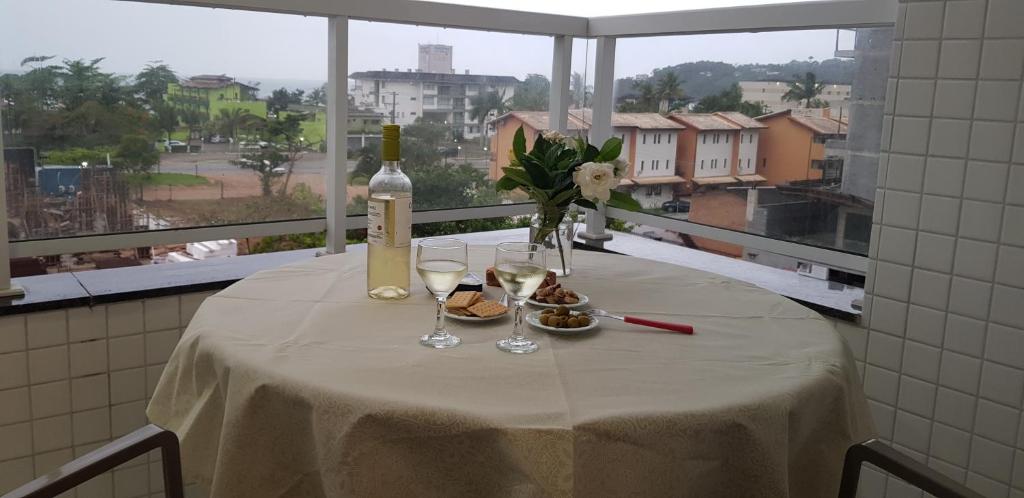 einen Tisch mit einer Flasche Wein und Gläsern in der Unterkunft Ubatuba - Praia das Toninhas in Ubatuba
