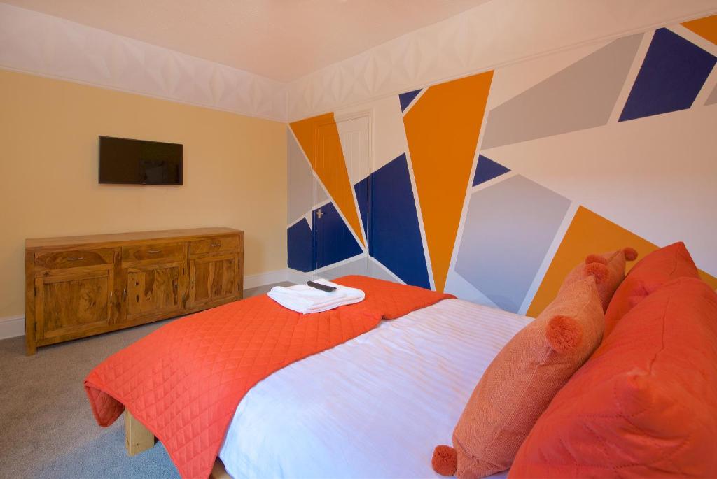 een slaapkamer met een bed met een oranje dekbed bij Ideal Abode Leonard chester in Chester