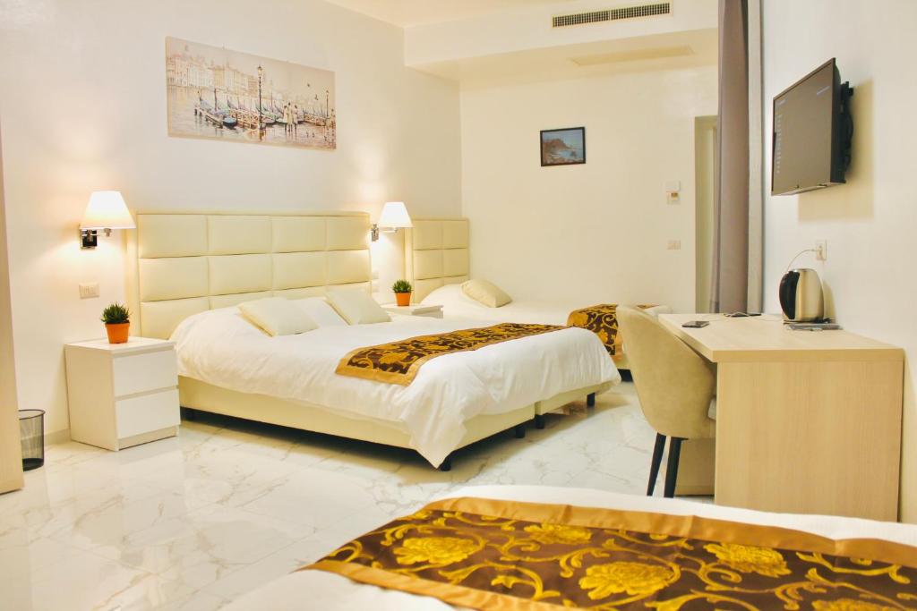 Habitación de hotel con 2 camas y escritorio en Hotel 900 Toscana en Florencia