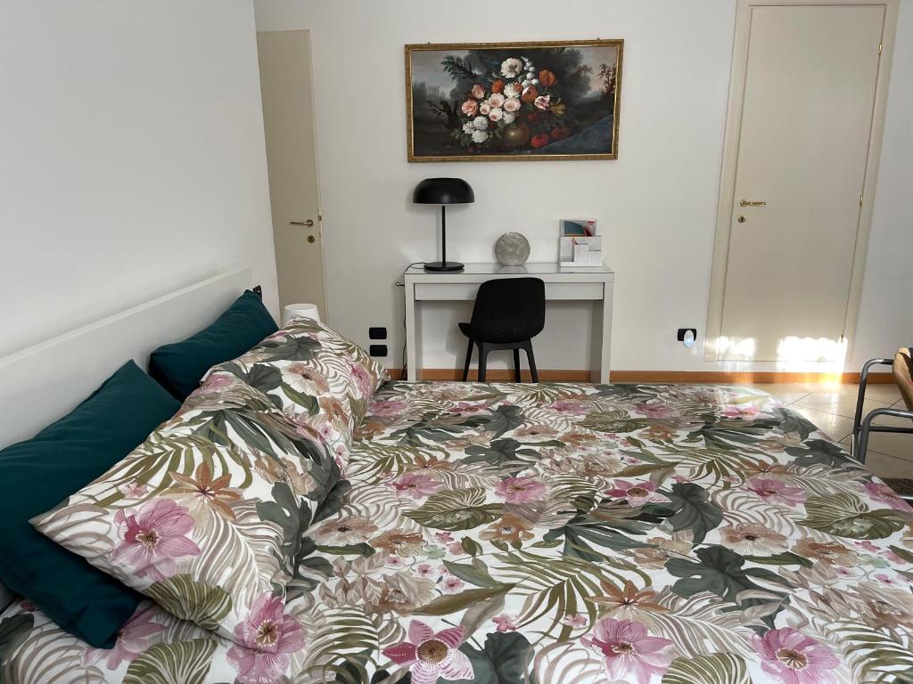 a bedroom with a bed with a floral bedspread at My Home by Sveva in Parma