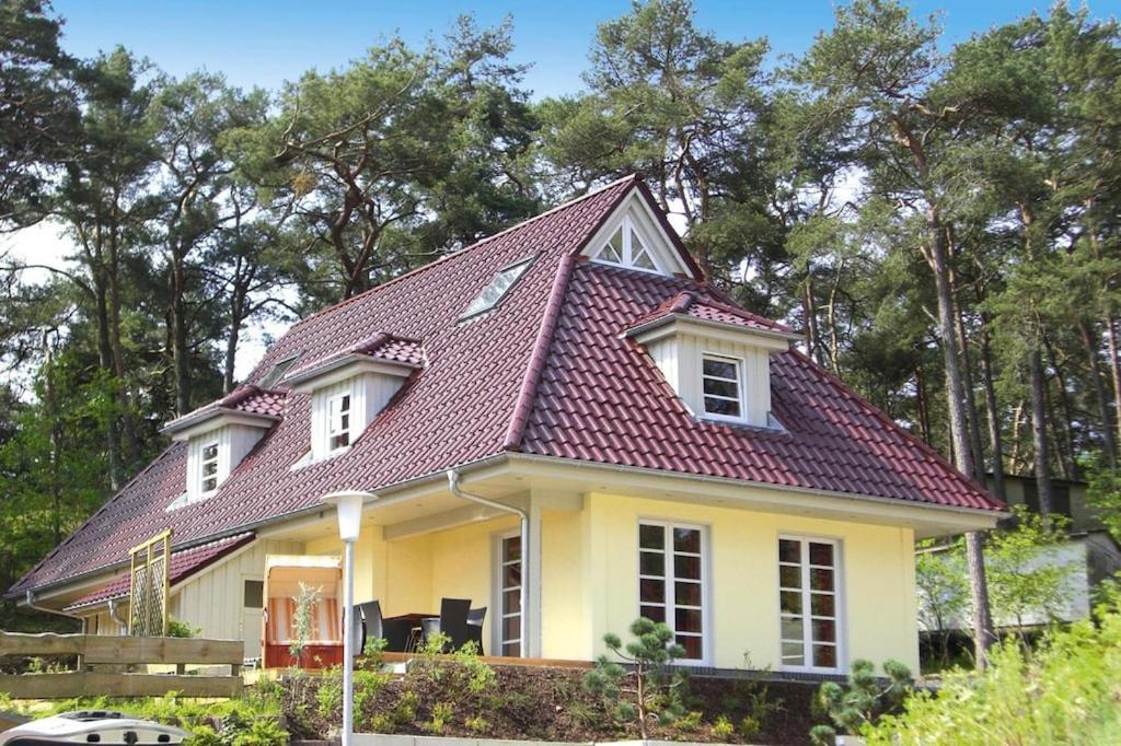 a yellow house with a red roof at Doppelhaushälfte Ostseehaus II, Trassenheide in Trassenheide
