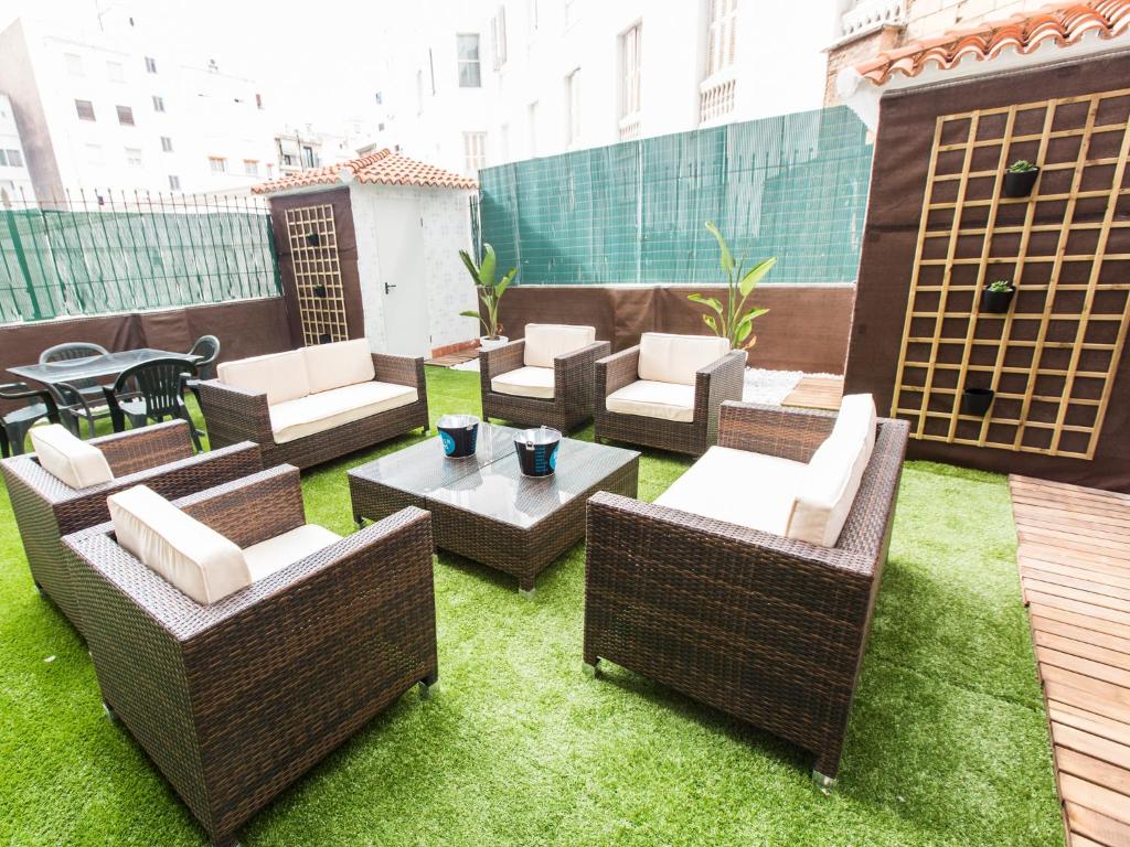 En la azotea hay un patio con mesas y sillas de mimbre. en Total Valencia Terrace, en Valencia
