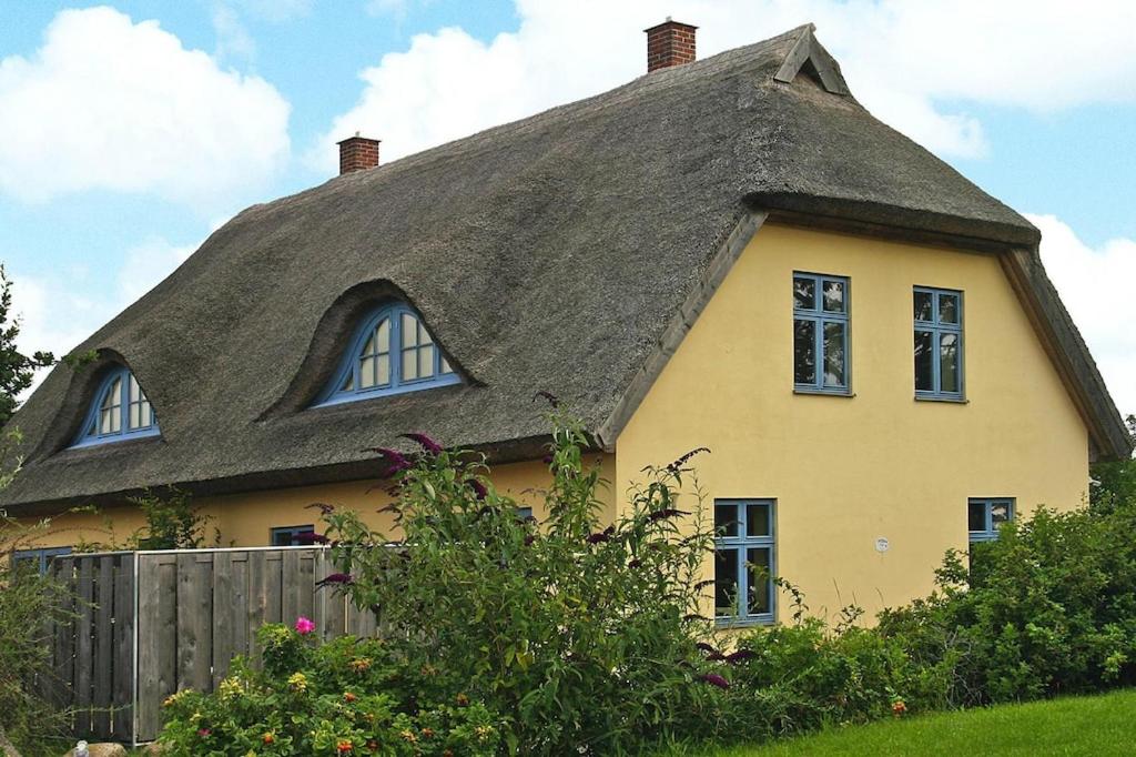 a yellow house with a thatched roof at Semi-detached house in the port village of Vieregge on the island of Rügen in Vieregge