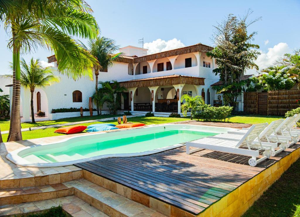 a swimming pool in front of a house at Pousada ON VIBE Cumbuco in Cumbuco