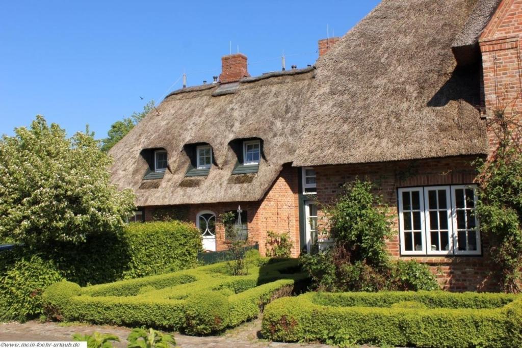 an old house with a thatched roof at Reethus WE 2, Föhrkiek in Borgsum
