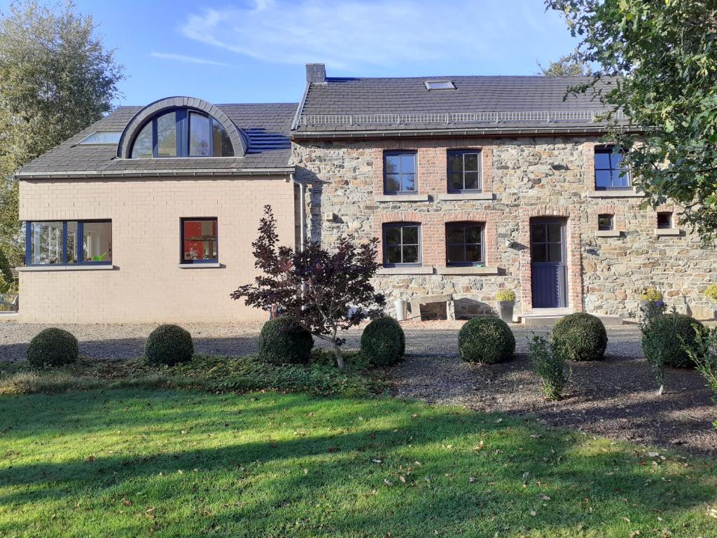 特鎮的住宿－Gîte de Bronromme - villa 5 chambres proche de Spa et Francorchamps，一座大型石头房子,前面有一座庭院