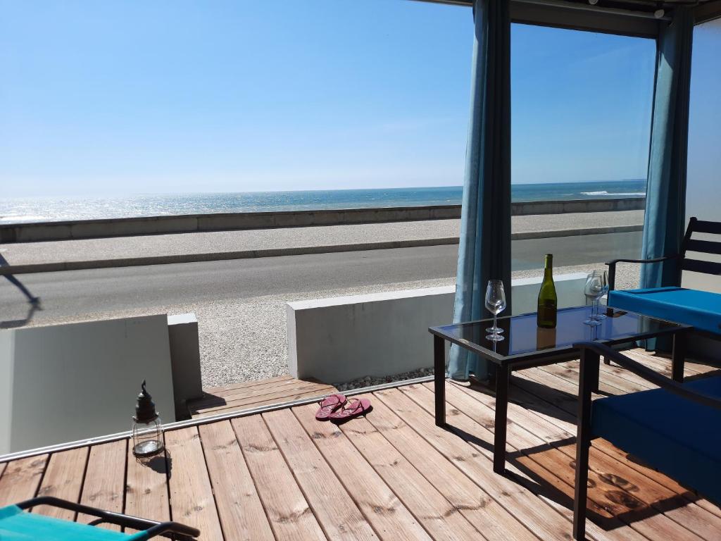 uma varanda com uma mesa e vista para a praia em Magnifique appartement face à la mer !! Résidence Charmette em Saint-Hilaire-de-Riez