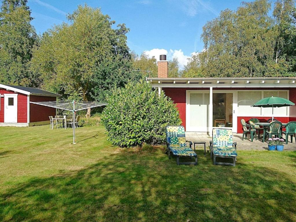 a yard with chairs and tables and a house at 6 person holiday home in Stege in Stege