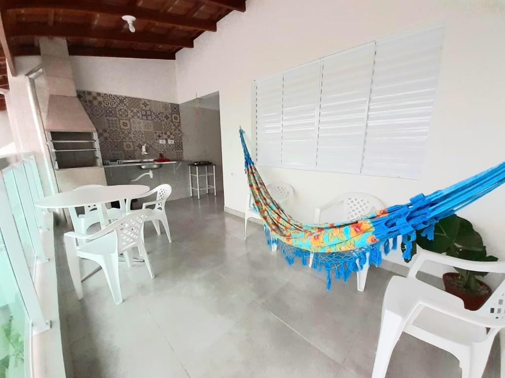 a hammock in a room with a table and chairs at A VER O MAR FLATS in Caraguatatuba