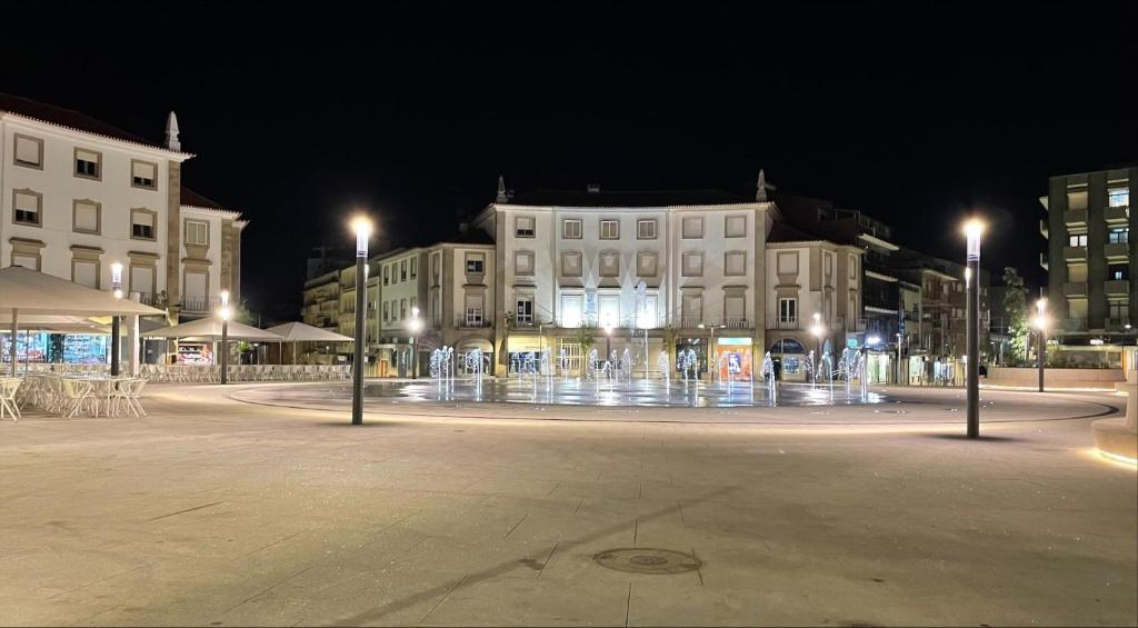 a fountain in the middle of a city at night at PRAÇA AL in São João da Madeira