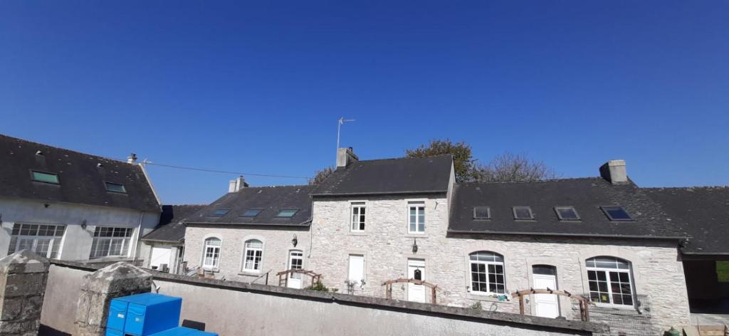 een wit gebouw met zwarte daken en een blauwe doos bij 14 maison 6 pers Les Gîtes Bigoudens in Plonéour-Lanvern