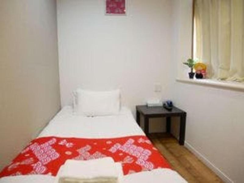 Postel nebo postele na pokoji v ubytování Tokyo shinjukutei Hotel Asahi gruop 東京新宿亭ホテル