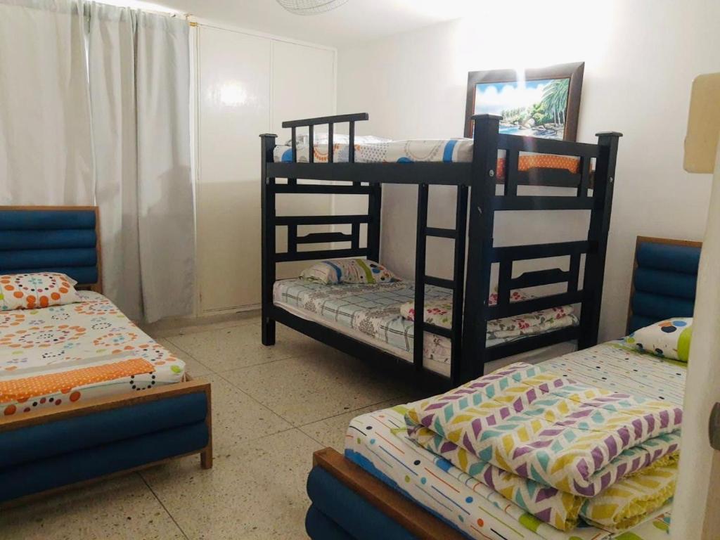 um quarto com 2 beliches e 2 camas individuais em Lindo Apartamento en Rodadero Santa Marta em Santa Marta