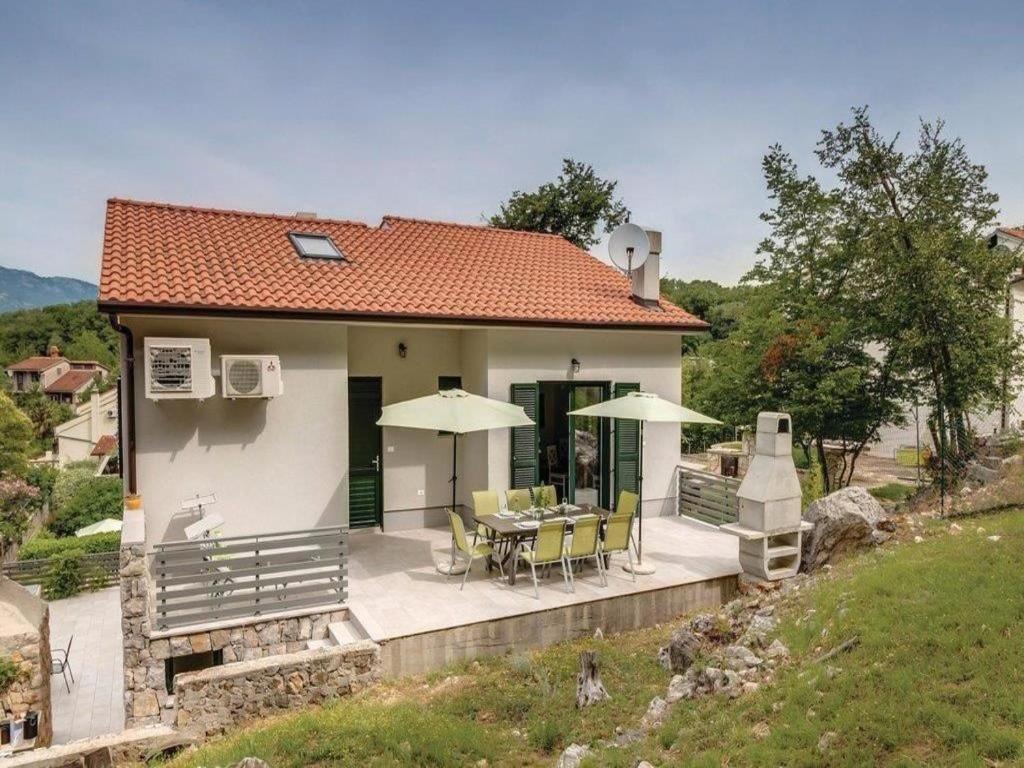 a house with a patio with a table and chairs at Apartments Grzic in Porozina