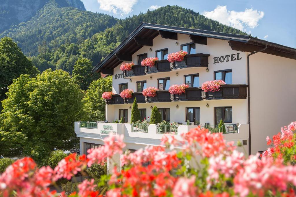ein Hotel mit Blumen auf den Balkonen eines Gebäudes in der Unterkunft Hotel Jenbacherhof B&B in Jenbach