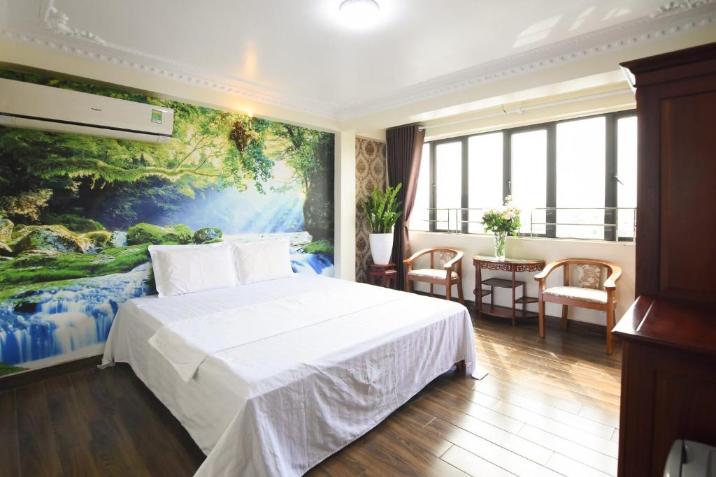 um quarto de hotel com uma cama e um quadro na parede em HAPPY GUEST HOUSE em Hai Phong