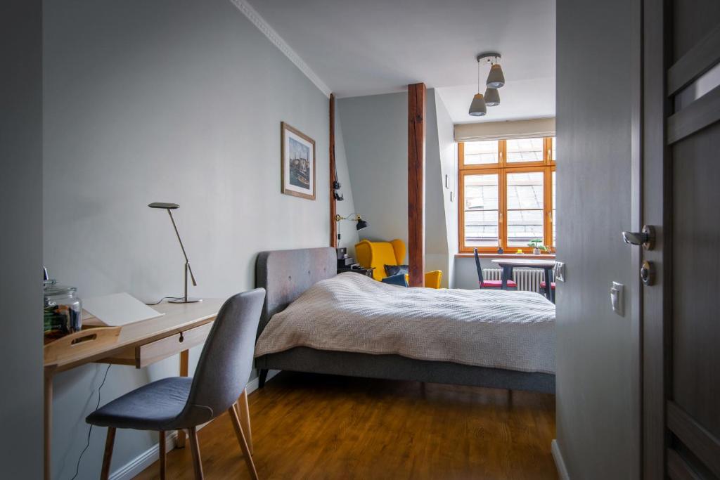 a bedroom with a bed and a desk and chair at Langer House apartment in Old Riga in Rīga