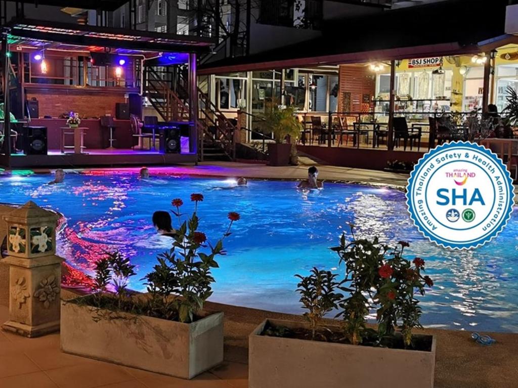 Baan Sabaijai Resort & Omsorgssenter في That Phanom: مسبح فيه ناس في المويه بالليل