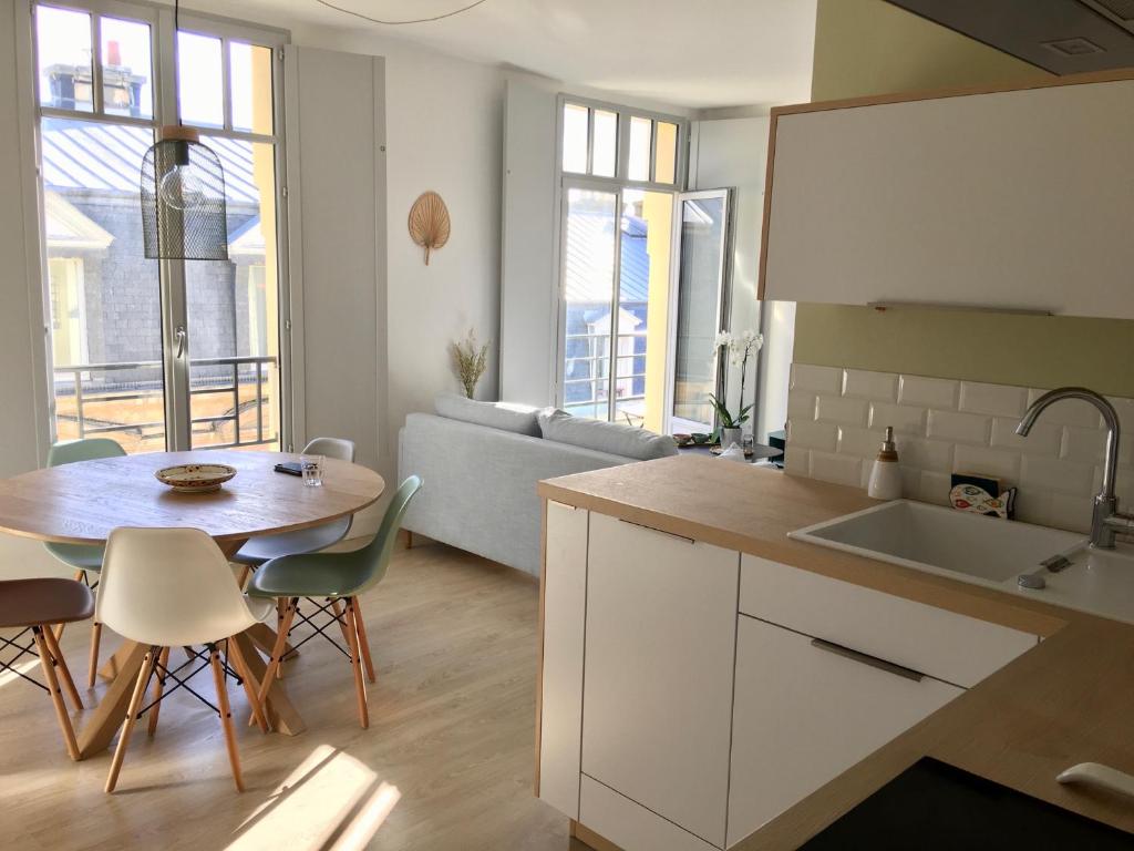 a kitchen and living room with a table and a couch at Cocon d'Emeraude Saint-Malo in Saint Malo