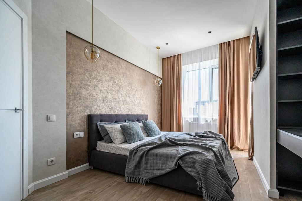 a bedroom with a bed and a large window at Атмосферні 4 квартирина поряд, 5 станція фонтану, з власним балконом fainorent in Odesa