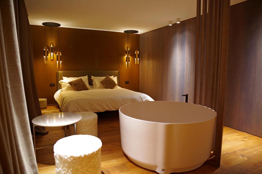 una camera d'albergo con letto e vasca di Chalet La Ciaseta a Pozza di Fassa