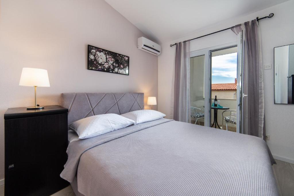 - une chambre avec un grand lit et une fenêtre dans l'établissement Apartments Divna, à Baška Voda