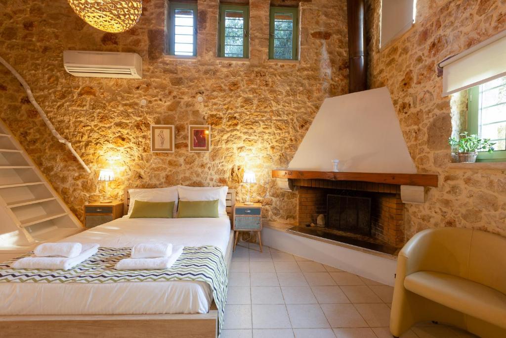 sypialnia z łóżkiem i kominkiem w obiekcie Green Oasis Residence with Hot Tub w mieście Atsipopoulo