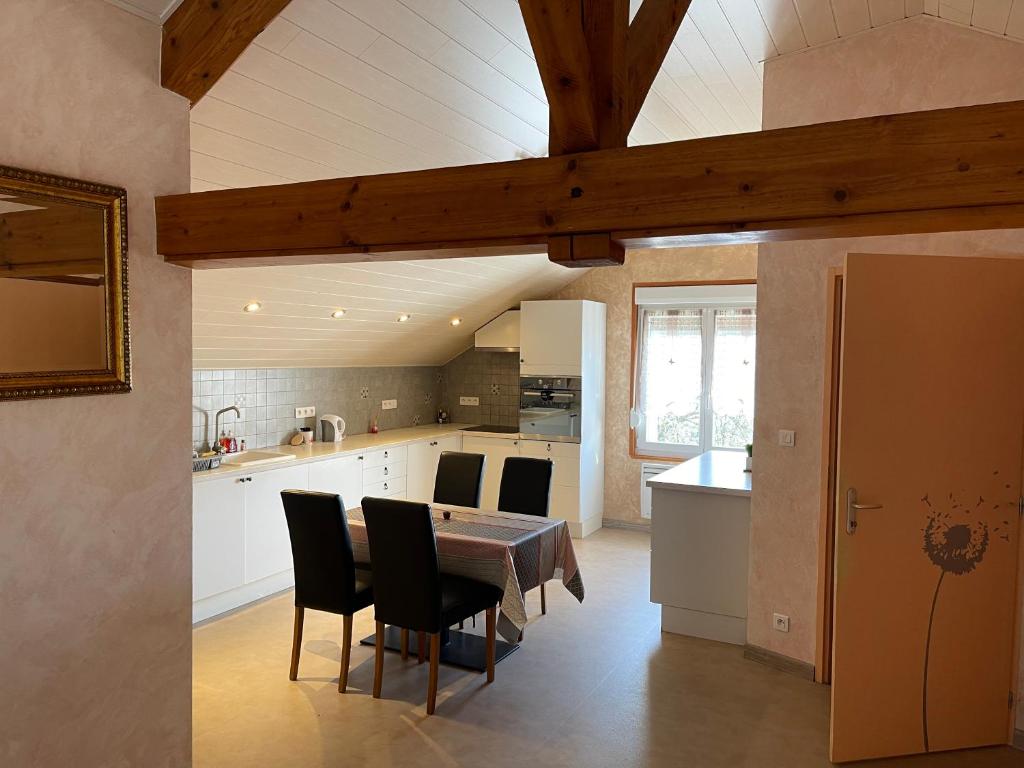 a kitchen and dining room with a table and chairs at Au cœur des stations de ski, 10 min de la suisse in Damprichard