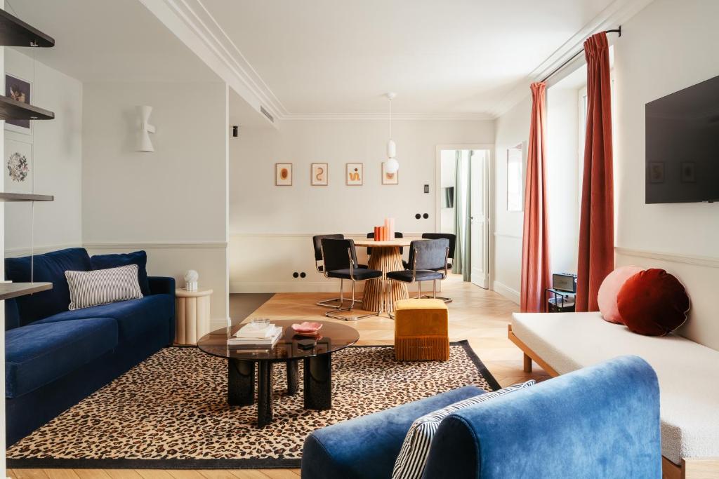 a living room with a blue couch and a table at My Maison In Paris - Champ de Mars in Paris